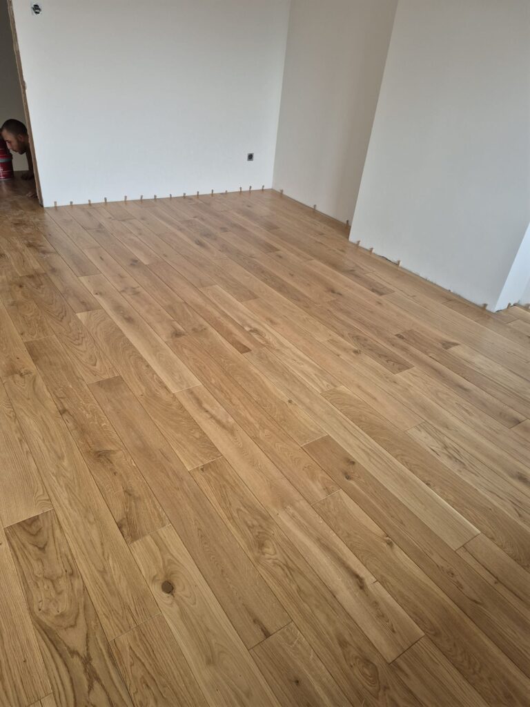 Podłoga lakierowana w salonie, drugie ujęcie, realizacja Flooren pod Warszawą
